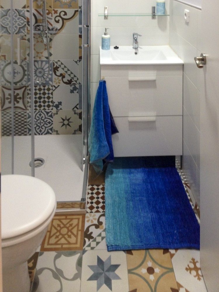 Baño con ducha de mampara y azulejo hidráulico estampado