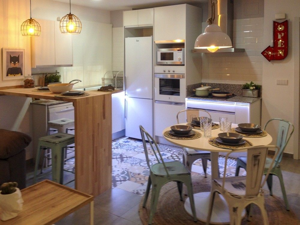 Cocina abierta con barra de madera y suelo hidráulico patchwork en calle Janini