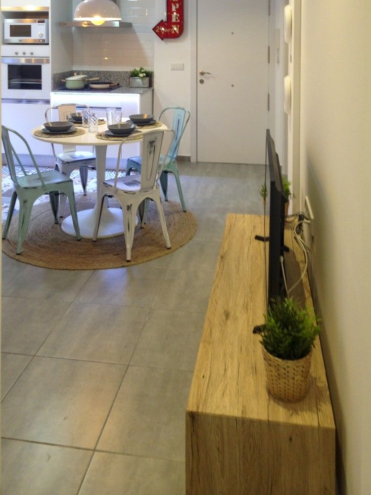 Salón con mueble de madera clara y suelo porcelánico gris