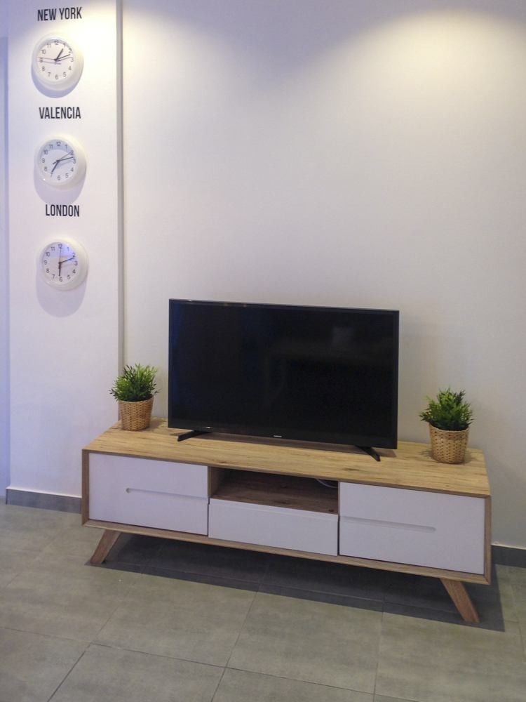 Mueble de televisión blanco y madera en apartamento de Valencia