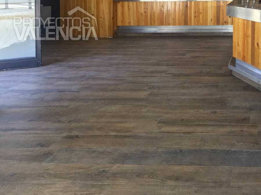 Suelo imitación madera oscura en la sala del bar reformado
