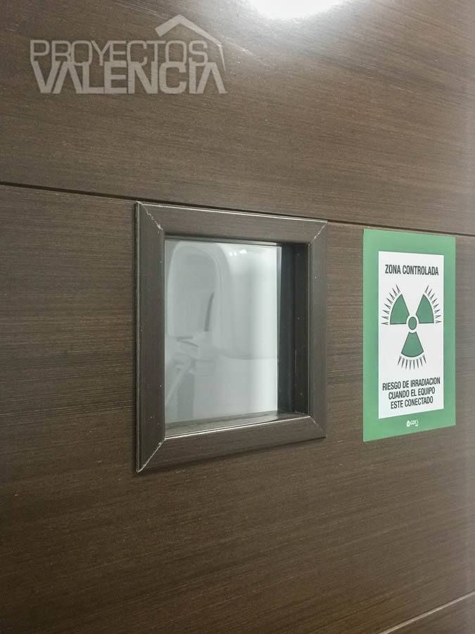 Puerta de madera oscura con visor y señal de zona controlada