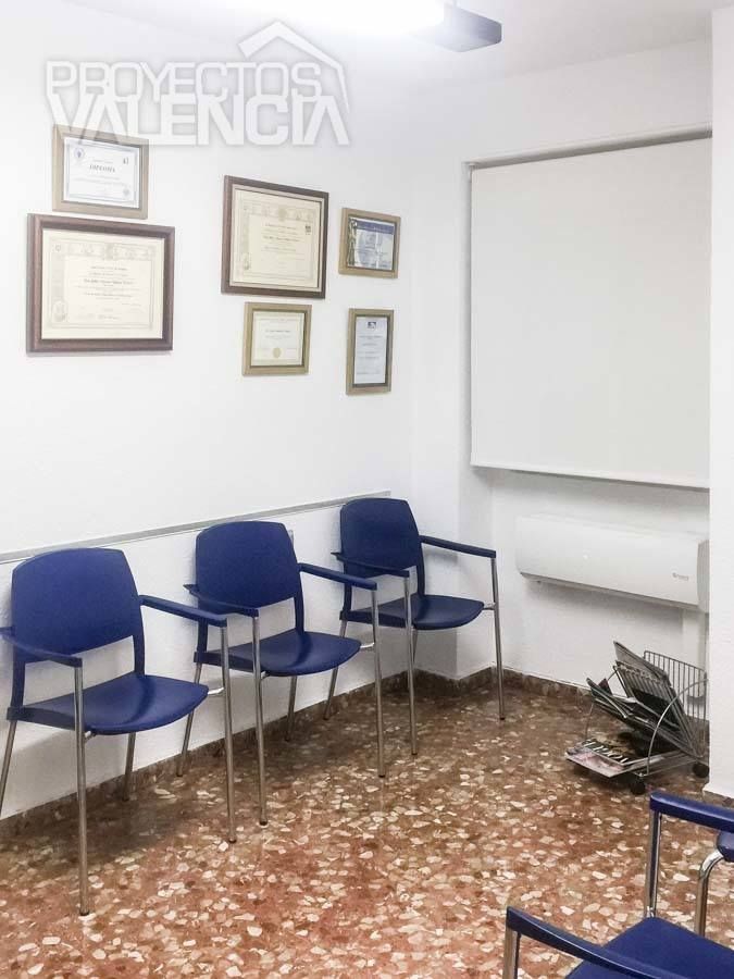 Sala de espera con sillas azules y paredes blancas