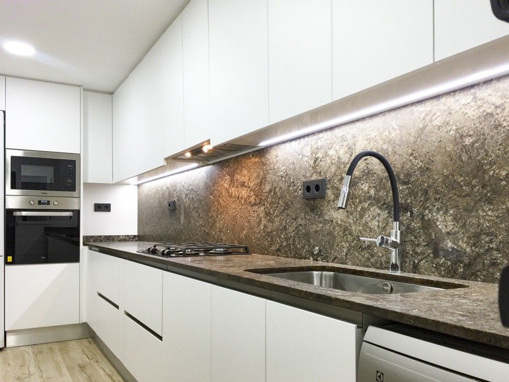 Cocina blanca sin tiradores con frontal de piedra natural en Archiduque Carlos