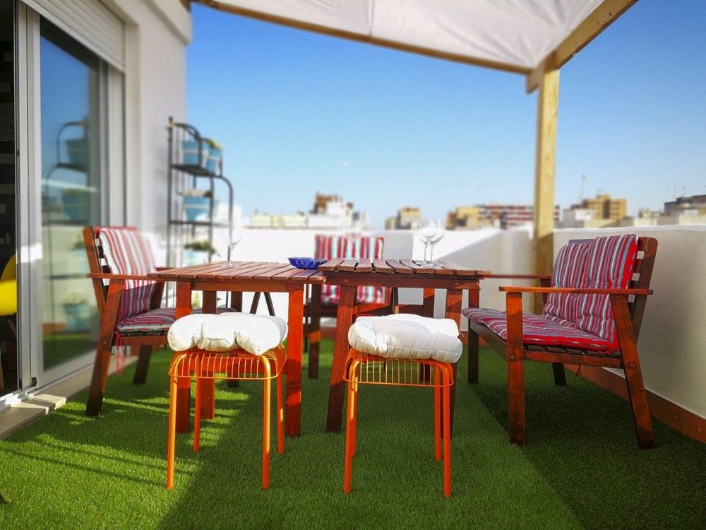 Terraza con césped artificial y pérgola con toldo blanco en Cullera