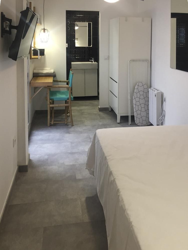 Dormitorio con escritorio de madera y baño privado al fondo