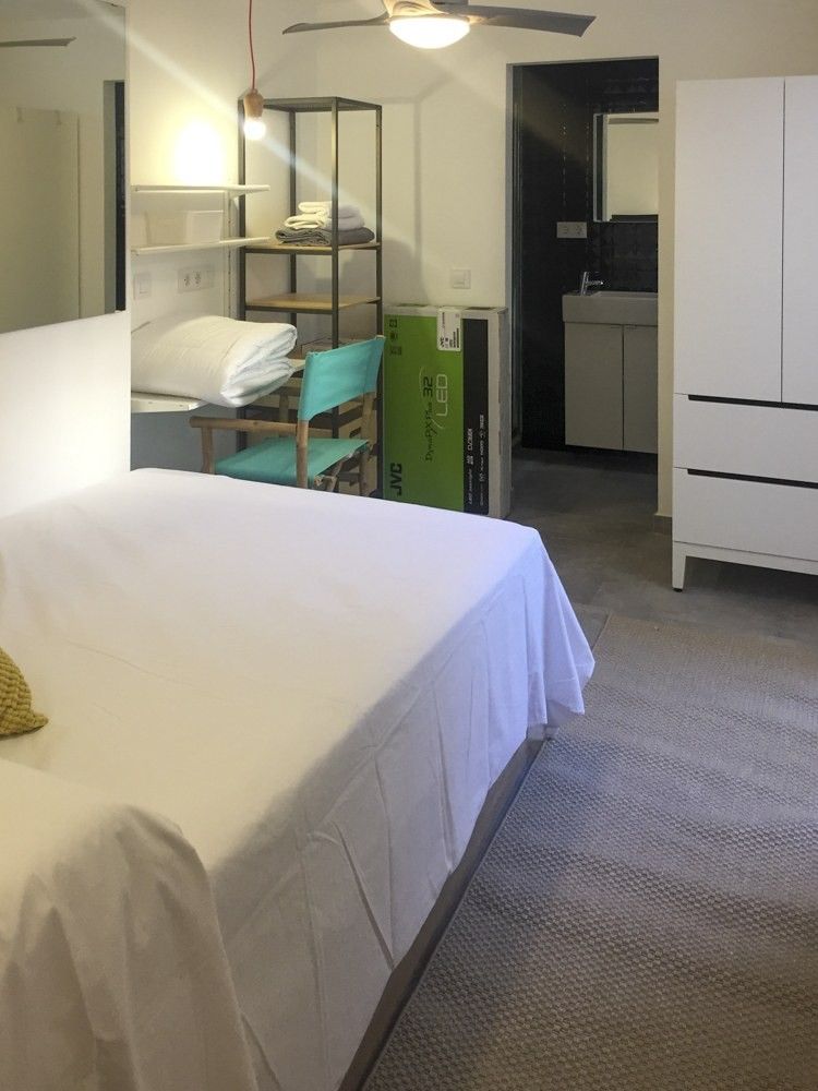 Dormitorio con estantería de madera y paso al baño privado