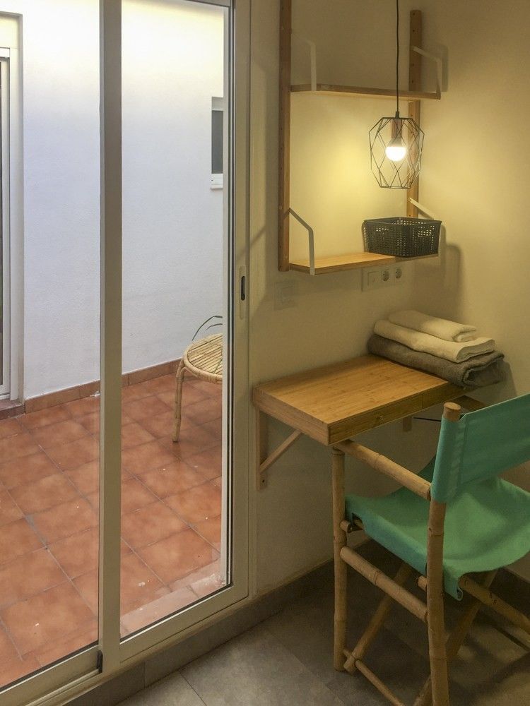 Escritorio de madera con lámpara colgante junto a la salida al patio