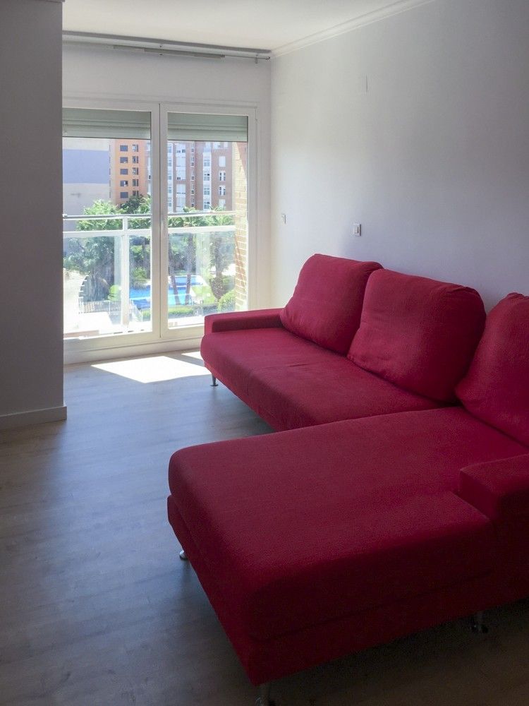 Salón con suelo imitación roble y ventanal en piso de Benicalap