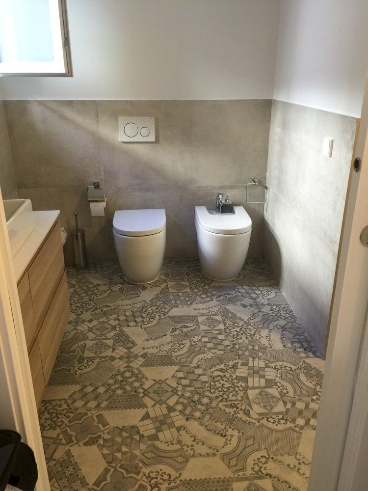 Baño con porcelánico gris de gran formato y suelo hidráulico en piso antiguo
