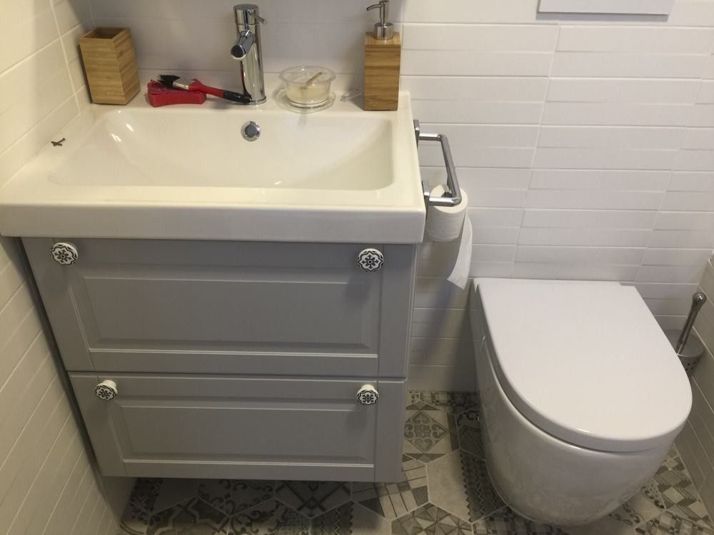 Mueble de lavabo gris de estilo clásico sobre suelo hidráulico