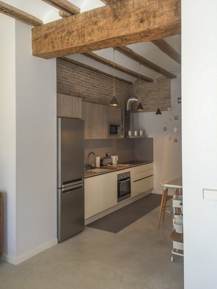 Cocina lineal blanca abierta con columna de frigorífico y horno