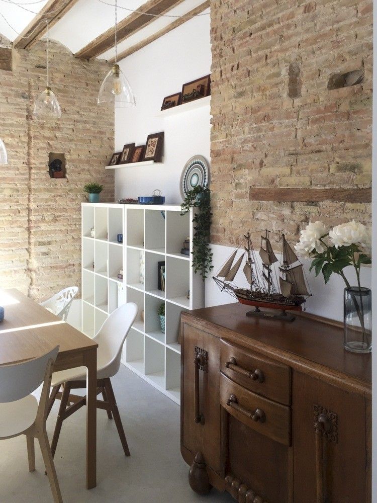 Comedor con mesa de madera, sillas blancas y aparador antiguo