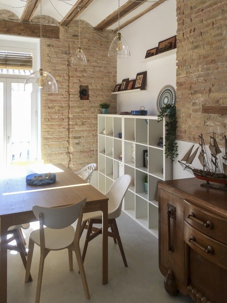 Comedor junto al balcón con muro de ladrillo macizo visto