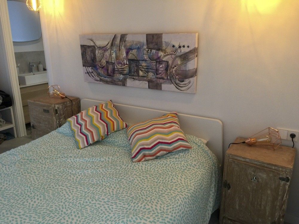 Dormitorio en blanco con cama doble y mesillas de madera