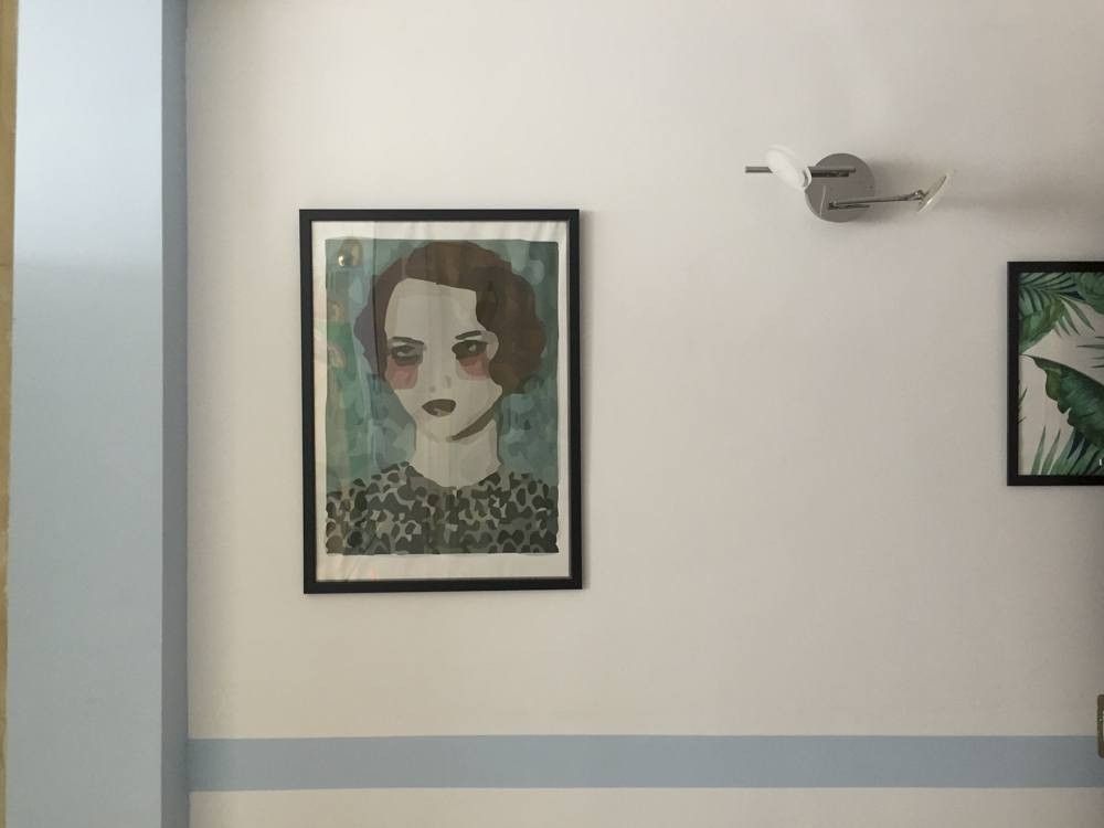 Lámina ilustrada sobre pared blanca con franja azul pintada