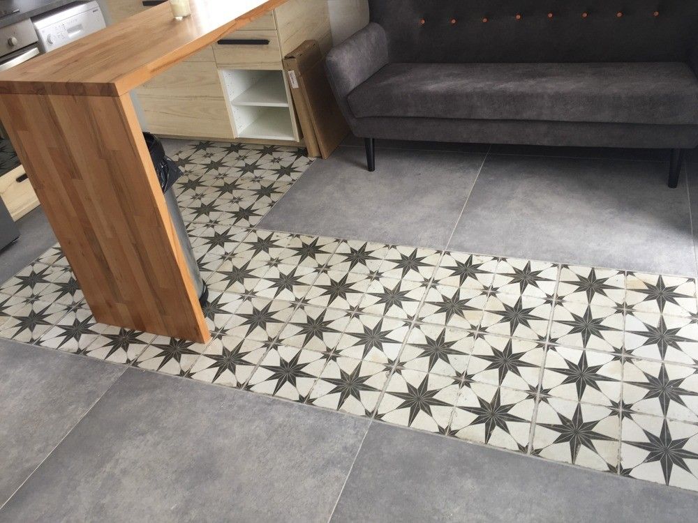 Baldosa hidráulica de estrellas junto a porcelánico gris y barra de madera