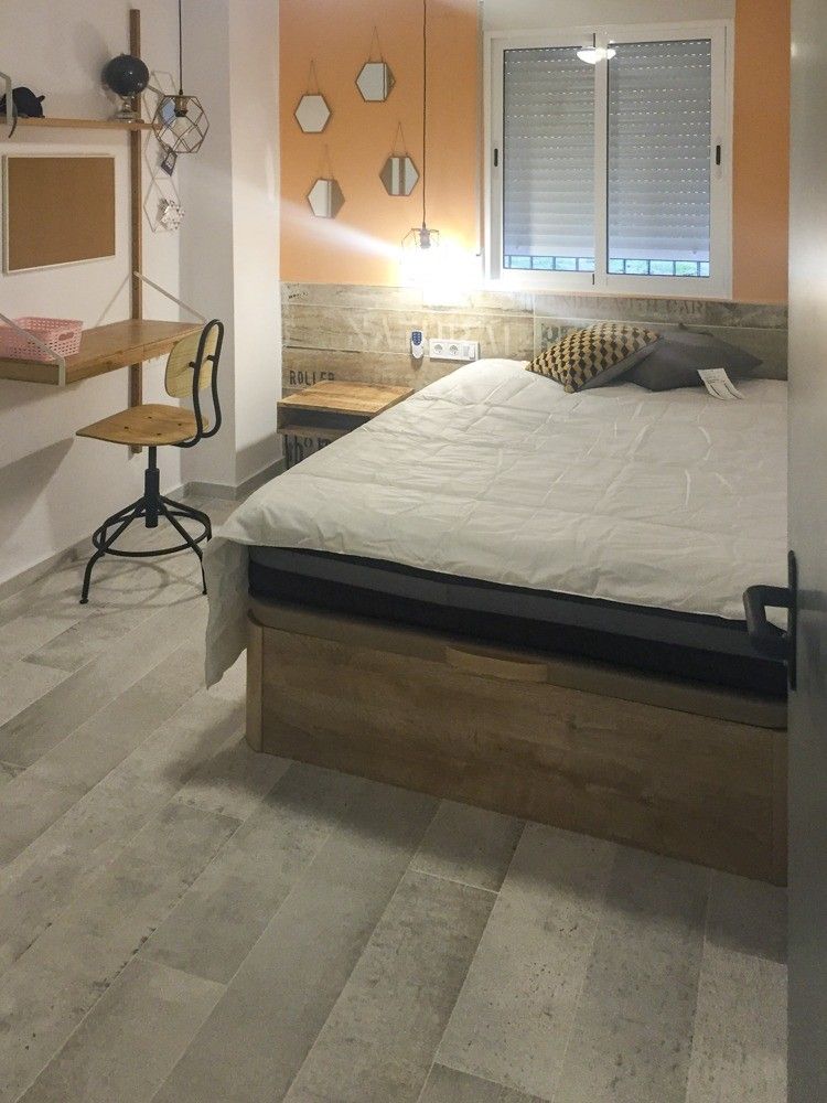 Dormitorio con pared naranja y zócalo imitación madera en calle Janini