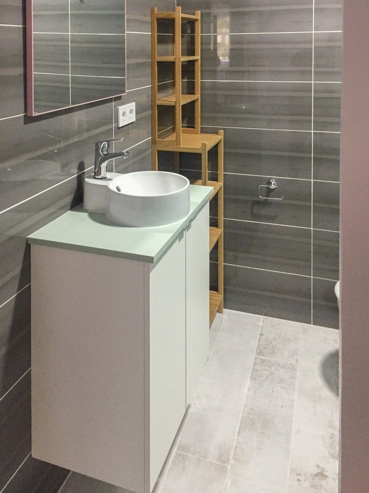 Baño con porcelánico gris y lavabo sobre encimera