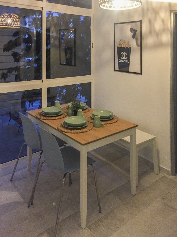 Comedor con mesa de madera clara junto a la ventana