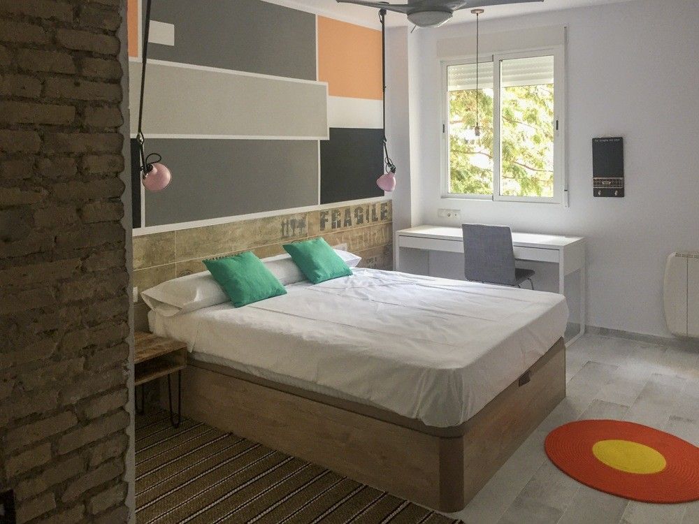 Dormitorio con franjas de color en la pared y escritorio en calle Janini