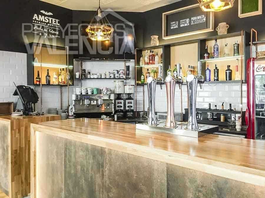 Barra con frente de porcelánico efecto óxido y encimera de madera