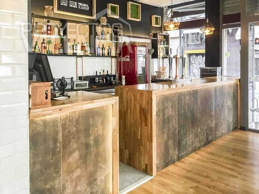 Barra de madera y metal con botellero sobre azulejo metro blanco