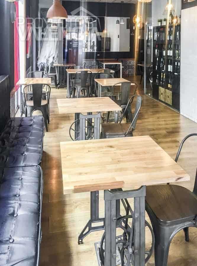 Banco corrido capitoné y mesas de madera maciza con pies de forja