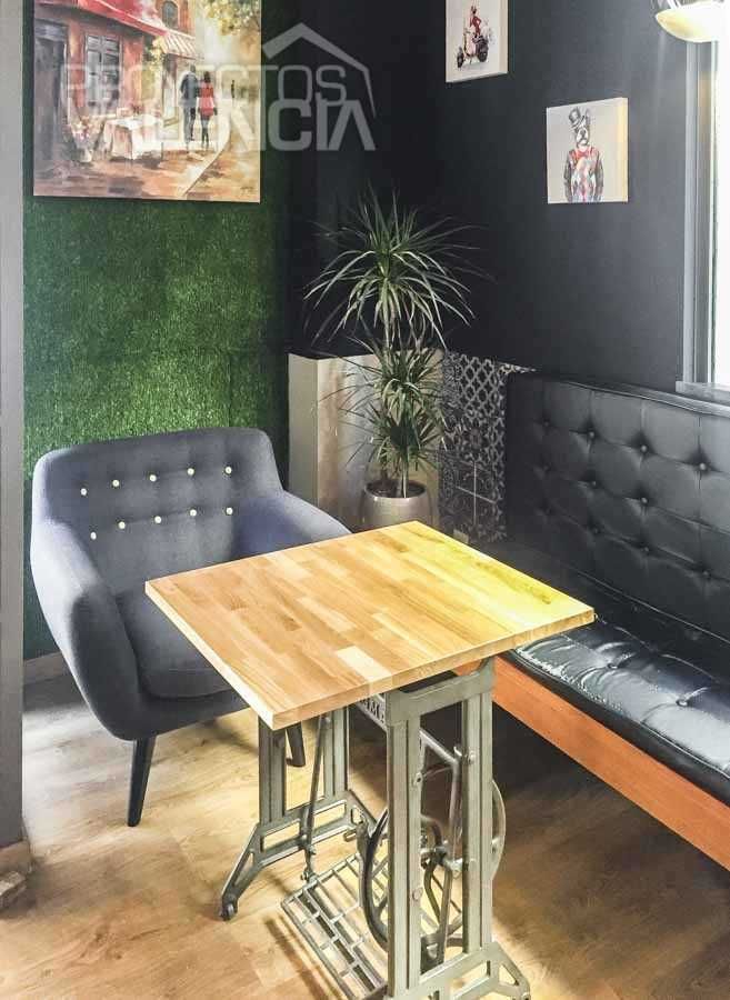 Rincón con butaca gris, banco capitoné y pared vegetal