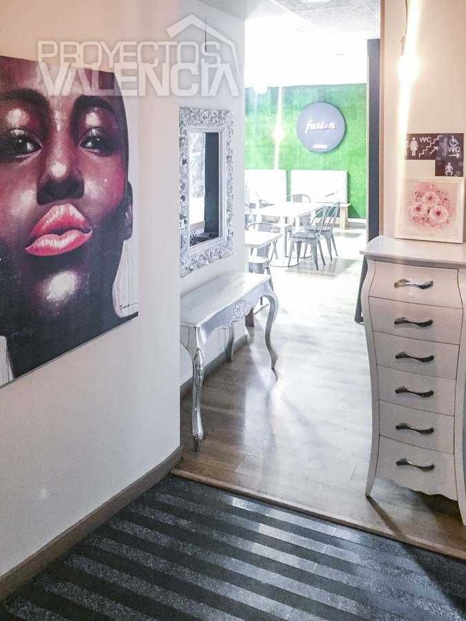 Entrada con retrato pintado, espejo y cómoda blanca