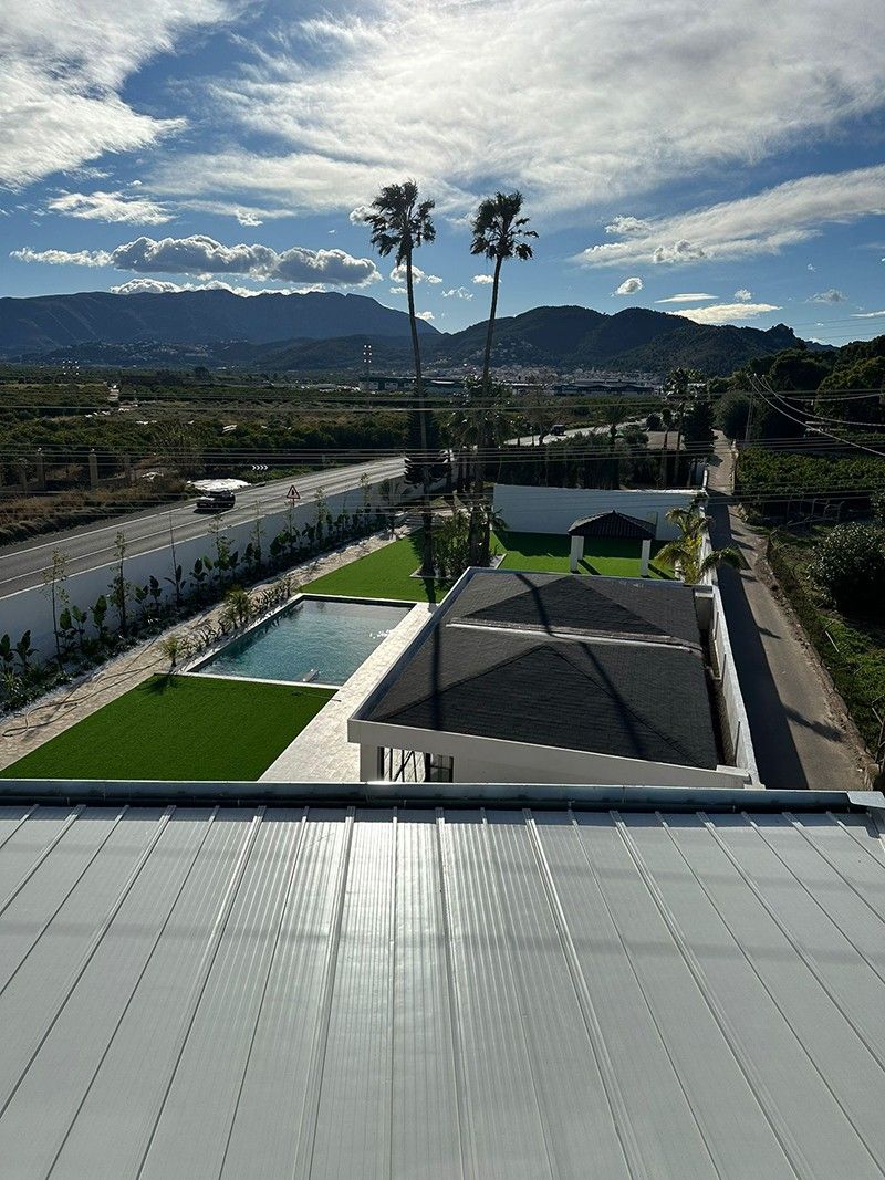 Vista desde la cubierta de la finca con piscina, huerta y montañas