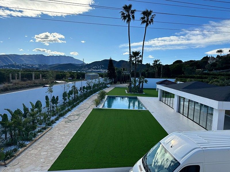 Vista elevada de la piscina, el césped y el camino de piedra