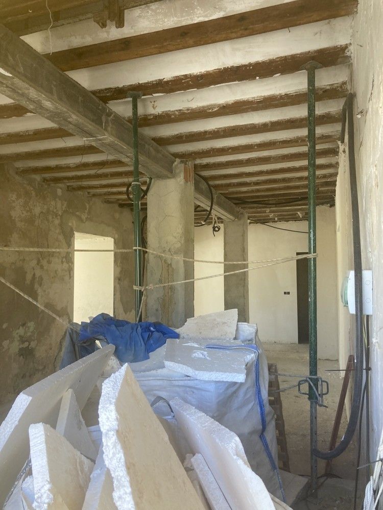 Interior con forjado de vigas y material acopiado durante la obra