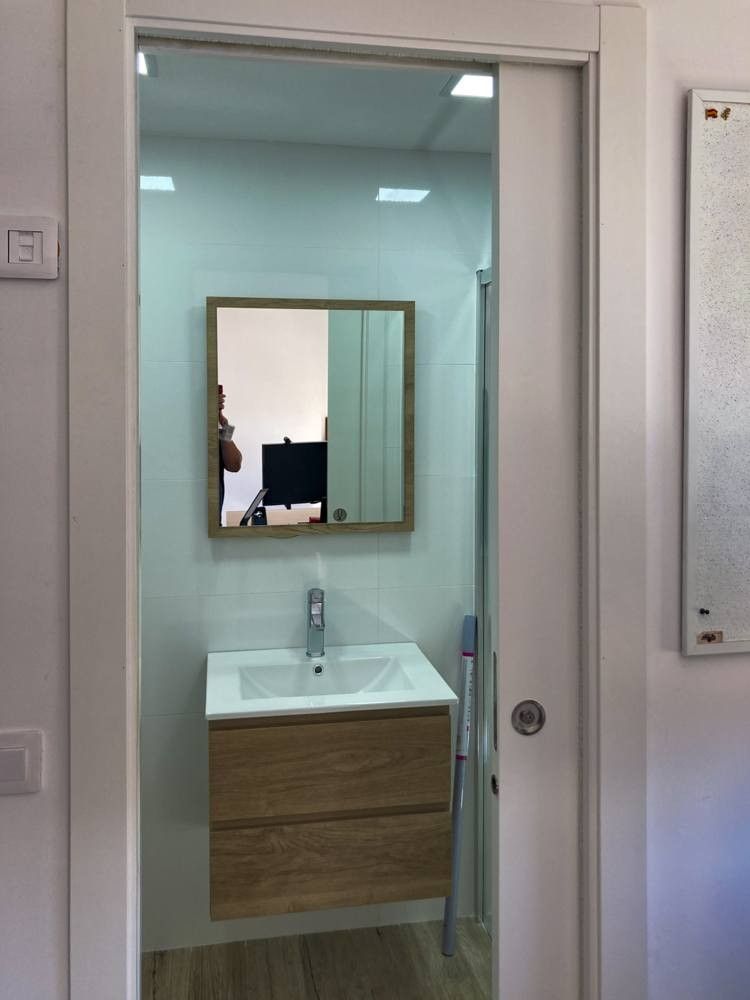 Mueble de lavabo suspendido de madera con espejo de marco a juego