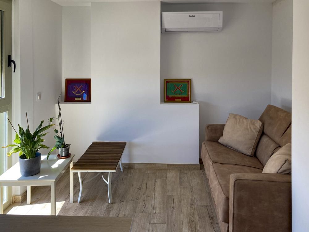 Estancia con suelo imitación madera y aire acondicionado junto a la terraza
